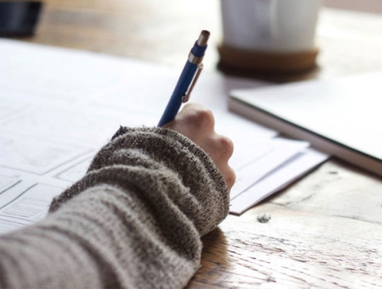 Male writing in notebook